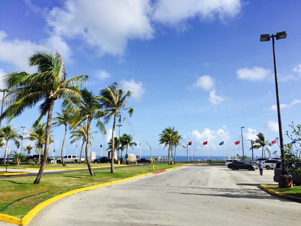 晴天の日のグアムの空港の駐車場と国旗
